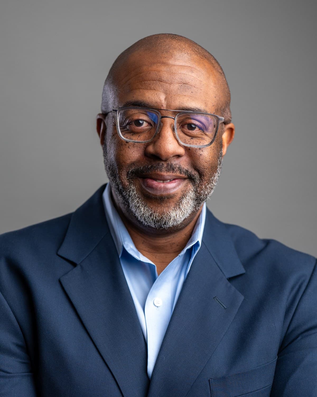 Craig C. Carlisle in a navy jacket and light blue shirt, studio portrait.